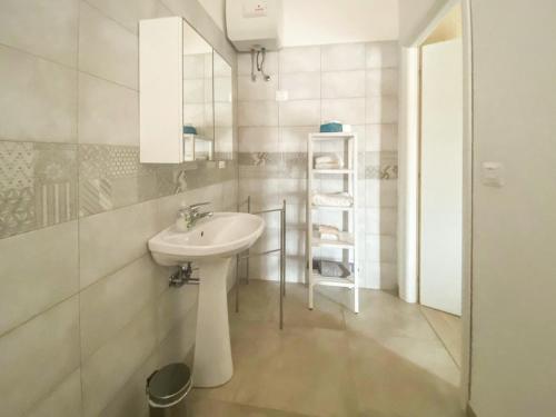 a white bathroom with a sink and a mirror at Blue Room - Camera Matrimoniale con Garage Privato in Bitonto