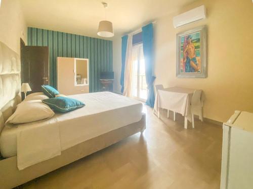 a bedroom with a large bed and a table at Blue Room - Camera Matrimoniale con Garage Privato in Bitonto