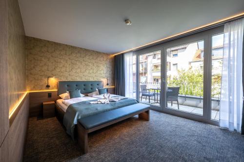 a bedroom with a bed and a large window at Stadthotel Münster in Münster