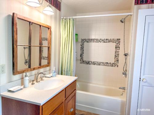 a bathroom with a sink and a tub at West Hill Farmhouse in Warren