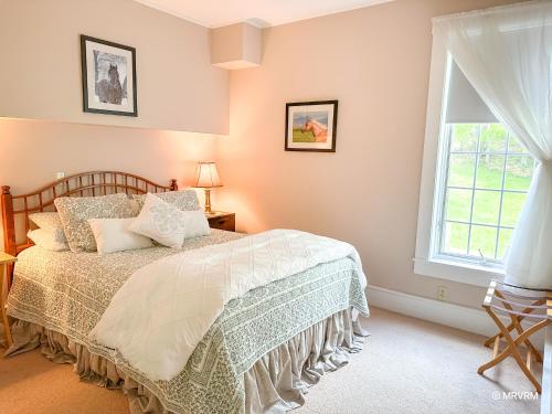 a bedroom with a bed and a window at West Hill Farmhouse in Warren