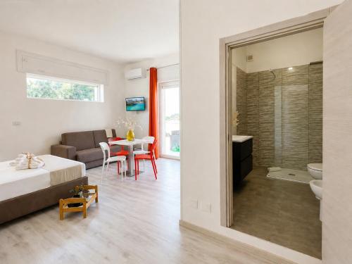 a bedroom with a bed and a table and a bathroom at RestHouse The Village in Nardò
