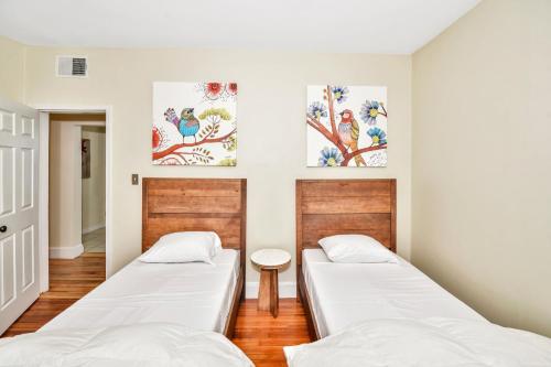 two beds in a room with paintings on the wall at Comfort Stay in Boston