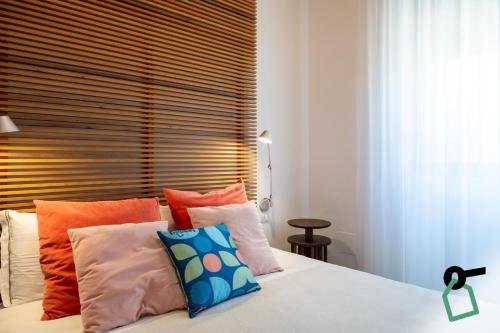 a bedroom with a bed with colorful pillows at Hotiday Torre Lapillo Centro in Torre Lapillo