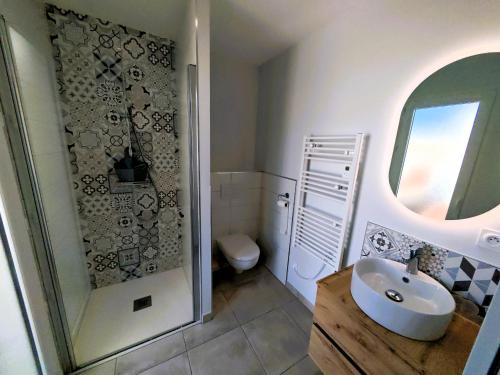 a bathroom with a sink and a toilet at La Pause Jardaise in Jard-sur-Mer