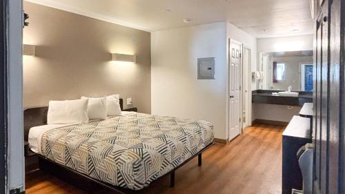 a bedroom with a bed and a bathroom with a sink at Studio 6 Greenville, SC in Greenville