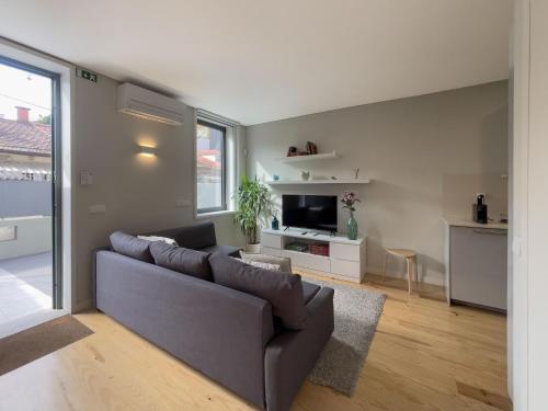 a living room with a couch and a tv at Allegro Patio House in Porto