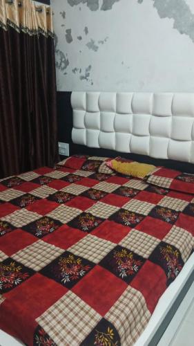 a bed with a quilt on top of it at OM Homestay in Dwarka