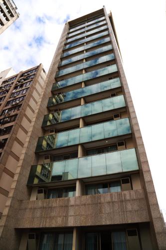 a tall building with glass windows at Promenade Pancetti Belo Horizonte in Belo Horizonte