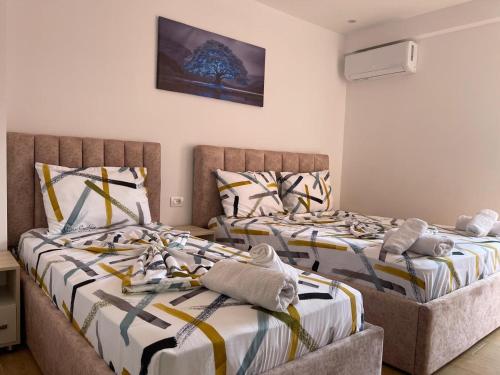 two beds sitting next to each other in a room at Hotel Reci in Peshkopi
