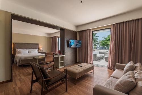 a hotel room with a bed and a living room at Hotel da Bahia by Wish in Salvador