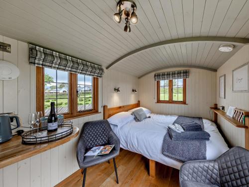 a bedroom with a bed and a table and chairs at 1 Bed in Bala oc-85259 in Frongoch