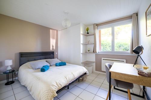 a bedroom with a bed and a desk and a window at Cocon chatillonnais in Châtillon-sur-Chalaronne