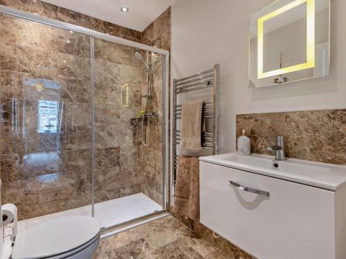 a bathroom with a shower and a toilet and a sink at 3 Bed in Swanage oc-ic098 in Swanage