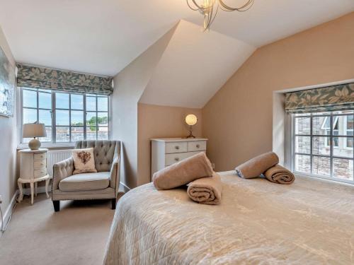 a bedroom with a bed and a chair and windows at 3 Bed in Swanage oc-ic098 in Swanage