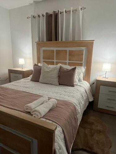 a bedroom with a large bed with two night stands at Calm Stay Monte Plata in Monte Plata
