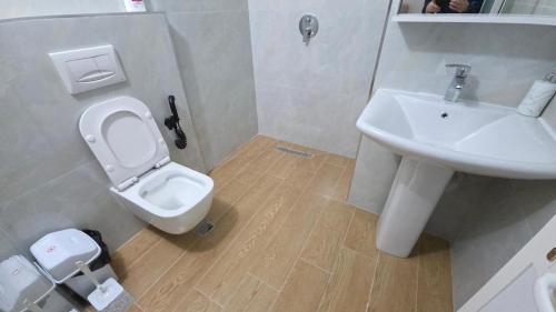 a bathroom with a white toilet and a sink at Hotel Reci in Peshkopi