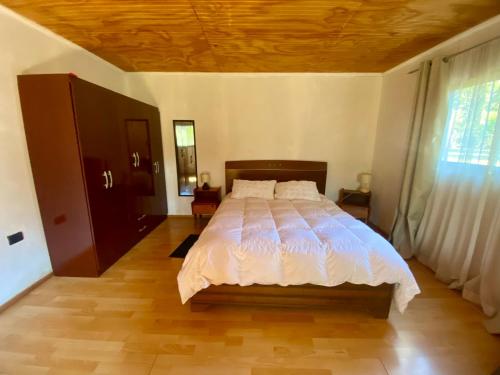a bedroom with a large bed with a wooden ceiling at Refugio Escondido in Isla de Maipo