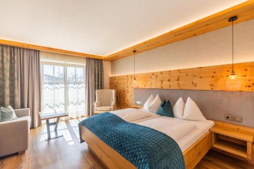 a bedroom with a large bed with a blue blanket at Landhotel Drei Eichen in Eugendorf