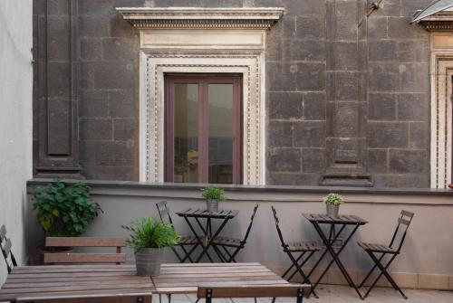 a patio with a table and chairs and a window at Il Taschino Suite in Naples