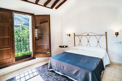 a bedroom with a bed and a large window at La Casa del Boticario in Alcalá del Júcar