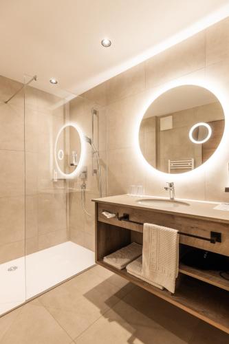 a bathroom with a sink and a shower and a mirror at Landhotel Drei Eichen in Eugendorf