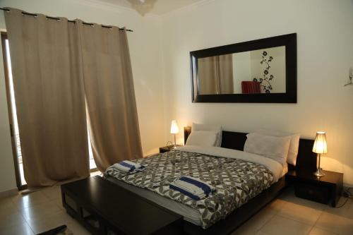a bedroom with a bed and a mirror on the wall at Apartment at Samarah Resort DeadSea C13-Families & couples only in Sowayma