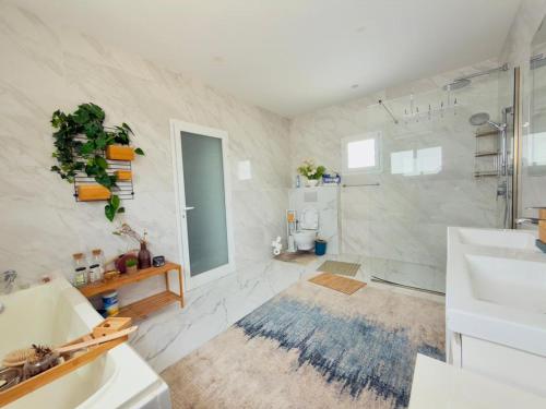 a bathroom with a tub and a shower and a sink at lunera Immo in Dakan