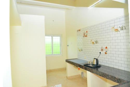 a kitchen with a counter top in a room at Arun Lodge and Cottage Near Thiruchendur in Korkai