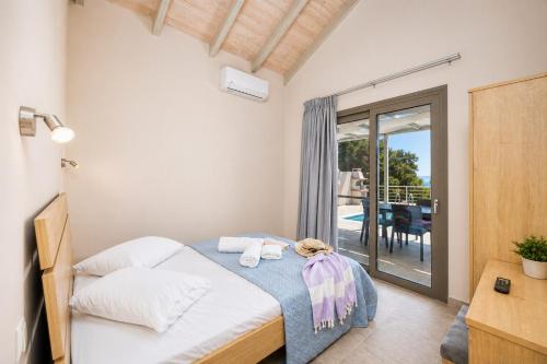 a bedroom with a bed and a balcony at Villa Angela in Trapezaki