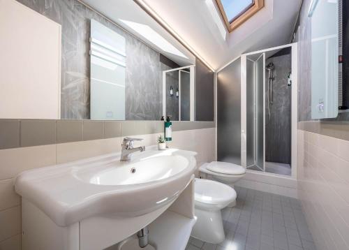 a white bathroom with a sink and a toilet at Hotel Castello in LʼAquila