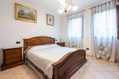a bedroom with a bed and a dresser and windows at Appartamento Mary Monte Grappa in Borso del Grappa
