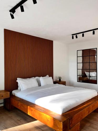 a bedroom with a large bed with a wooden headboard at Woodland Retreat in Ampoiţa
