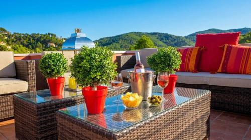 two tables with wine glasses and potted plants on a patio at Villa Sitges El Olivo High Comodity AC Pool Heated 30º Optional Real Garden Pool XXL 10 min drive from Sitges in Olivella