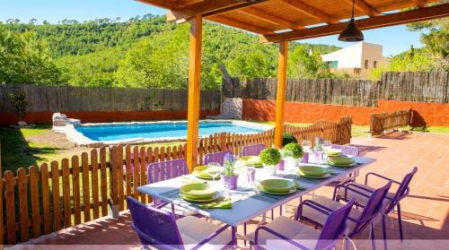 a table and chairs on a patio with a pool at Villa Sitges El Olivo High Comodity AC Pool Heated 30º Optional Real Garden Pool XXL 10 min drive from Sitges in Olivella