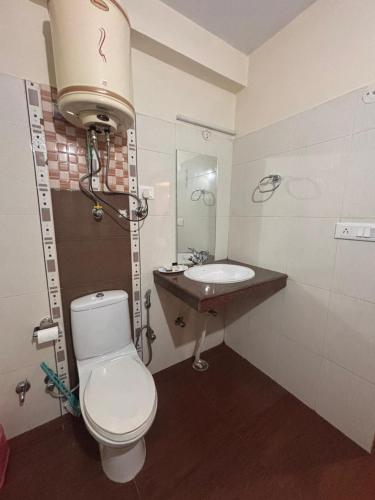 a bathroom with a toilet and a sink at Hexon Stays in Manāli