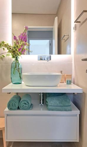 a bathroom with a sink and a mirror and towels at Allegro Patio House in Porto