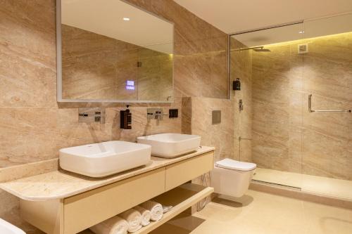 a bathroom with a sink and a toilet and a mirror at Seashell Suites in Abuja