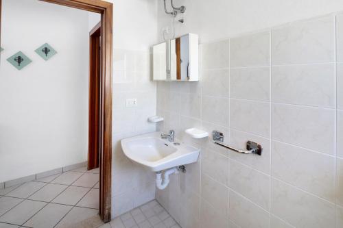 a white bathroom with a sink and a mirror at Residenza Stella Y in Bibione