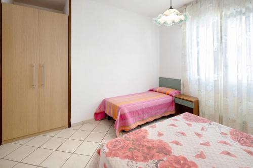 a bedroom with two beds and a chandelier at Residenza Stella Y in Bibione