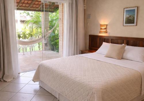 a bedroom with a bed and a large window at Hotel Cumuruxatiba in Cumuruxatiba