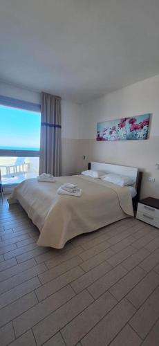 a bedroom with a large bed with a large window at Miramare Castello in Castelsardo