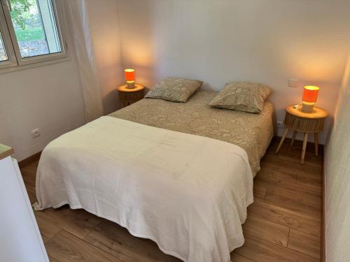a bedroom with a bed and two lamps on two tables at Chez Christine in Callian