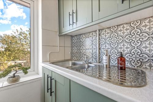 a kitchen counter with a sink and a window at Modern 2-Bed House in Reading in Reading