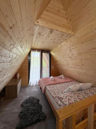 ein Schlafzimmer mit einem Bett in einem Holzzimmer in der Unterkunft Vikendica Harbaš in Cazin