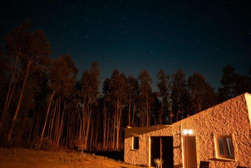 a night view of a stone building in the middle of a forest at Luxury Romantic Retreat with Hot Tub & Pool in Tábua