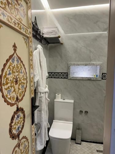 a bathroom with a white toilet in a room at Hotel Almas Meknes in Meknès