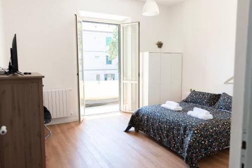 a bedroom with a bed and a sliding glass door at 2 camere fronte Ospedale - Centro e Mare a piedi in Pescara
