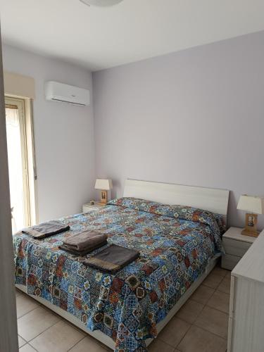 a bedroom with a bed with a quilt on it at Casa al mare Sicilia in Fondachello