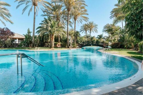 a large swimming pool with palm trees in a resort at R2 Rio Calma in Costa Calma